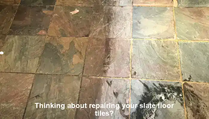 Cracked slate floor tiles with worn patches needing repair suitability assessment