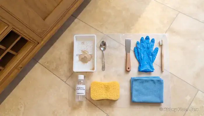 Small travertine repair materials arranged beside a tile