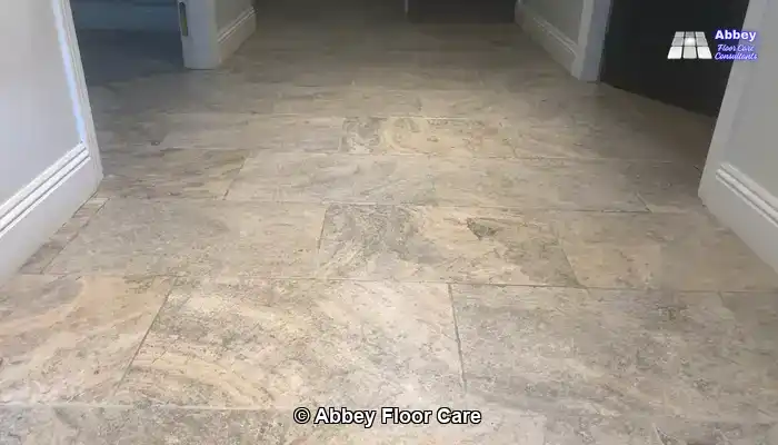 Rotary machine and wet vacuum deep cleaning a tumbled travertine floor and extracting dirty slurry