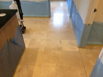 Kitchen limestone floor before surface refinement, showing dullness and fine wear from daily use