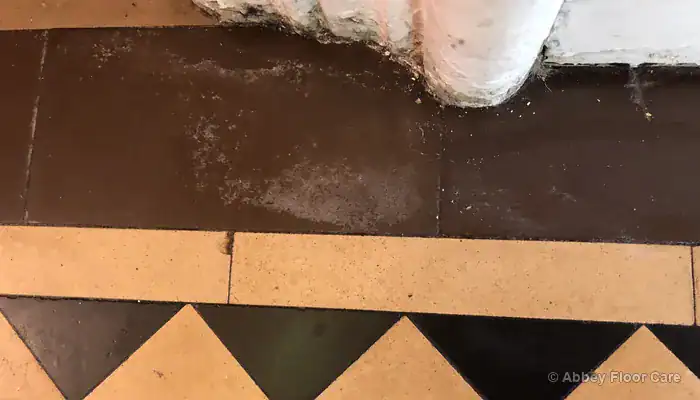 White salt deposits visible on Victorian tiles caused by moisture movement through the floor