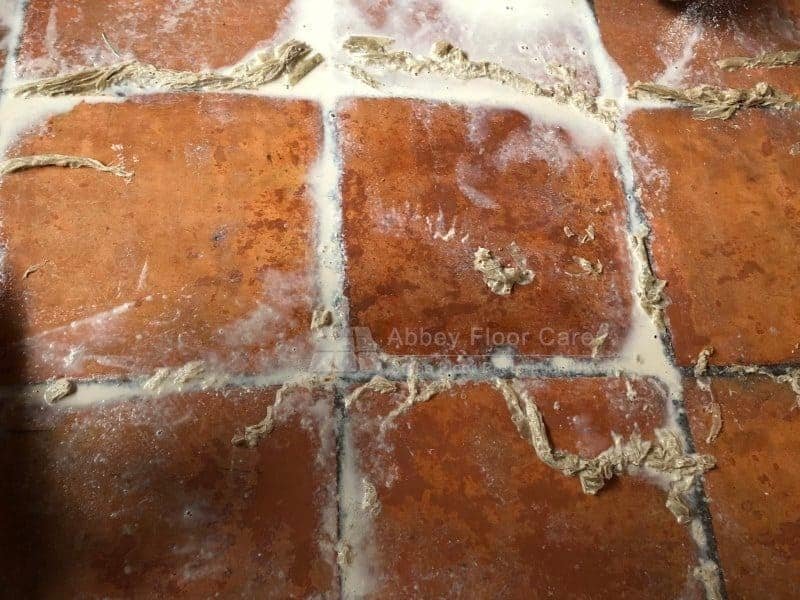 Careful hand removal of heavy sealer residue from terracotta