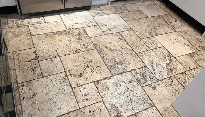Heavily soiled travertine floor before professional cleaning and restoration in Surrey