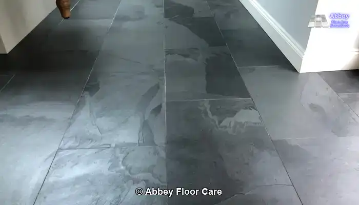 Slate floor tiles darkened by water, showing the temporary depth homeowners expect from a wet look finish