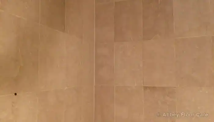 Dull, patchy appearance developing across marble shower wall tiles