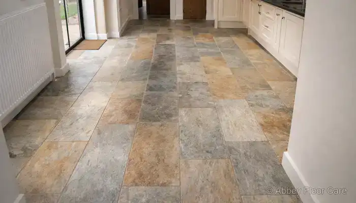 Sandstone floor showing darker traffic areas and uneven appearance